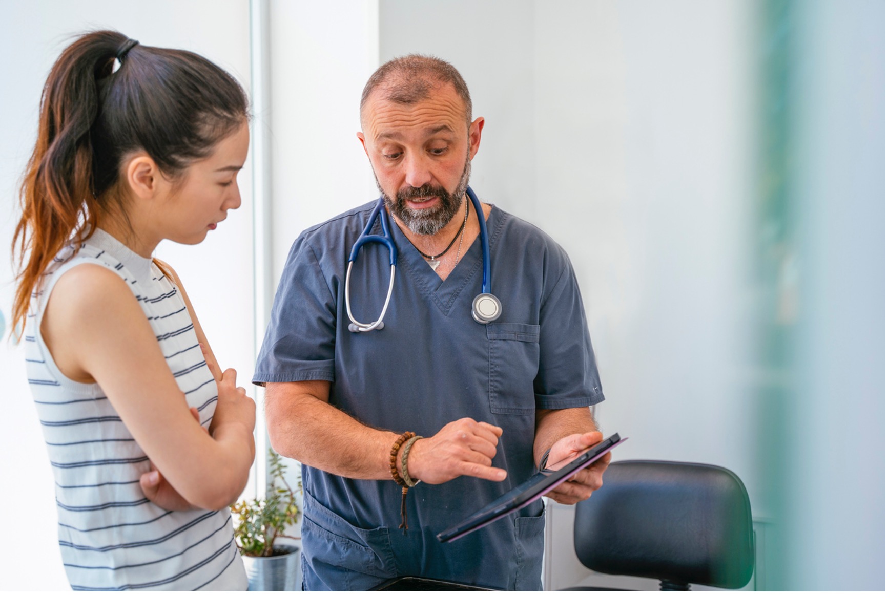 A person and person looking at a tablet, Worried About the Costs of Pet Care?